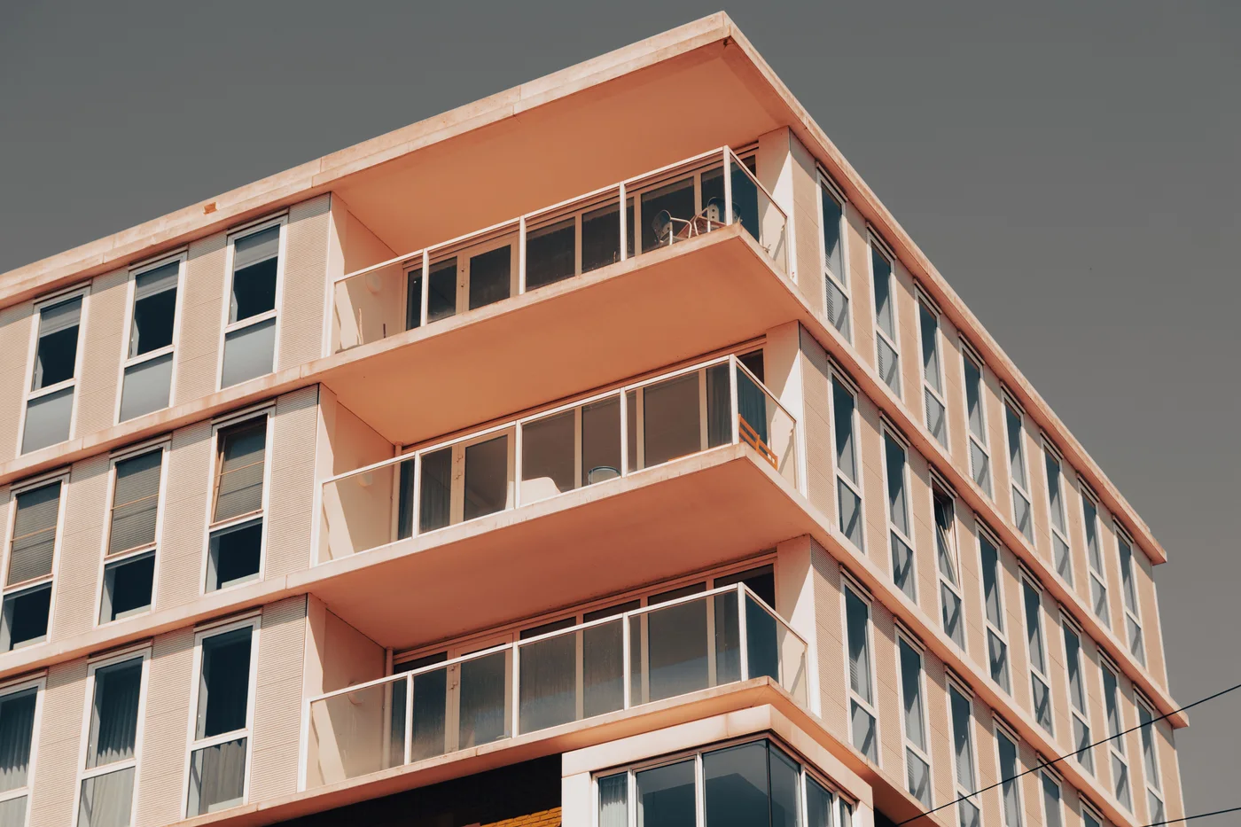 Contemporary apartment facade with terracotta balconies, illustrative architecture